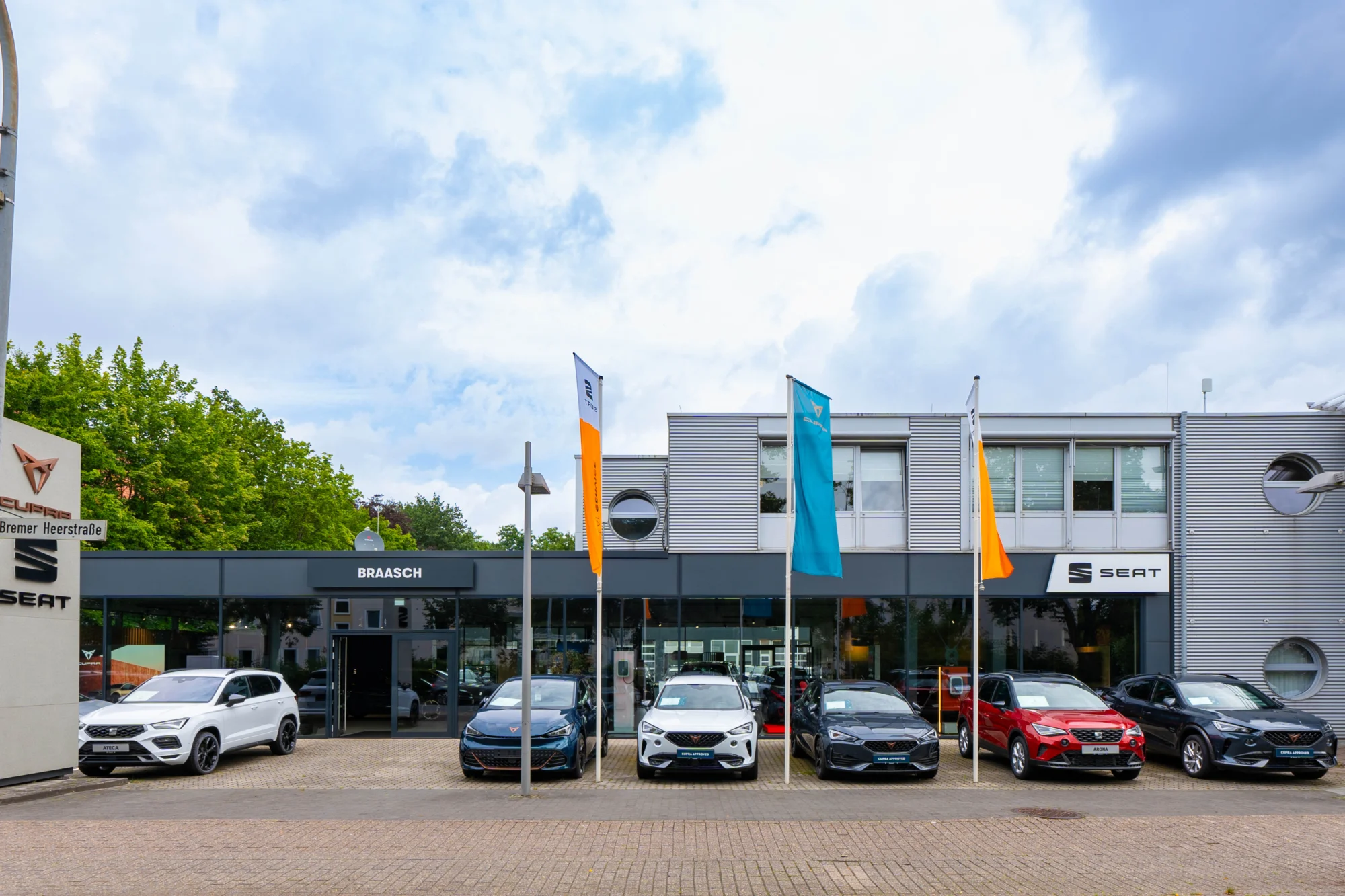 Seat und CUPRA Garage Oldenburg Ansicht vorne vorm Gebäude, Autos stehen aufgereiht davor. Markenlogos oben rechts.