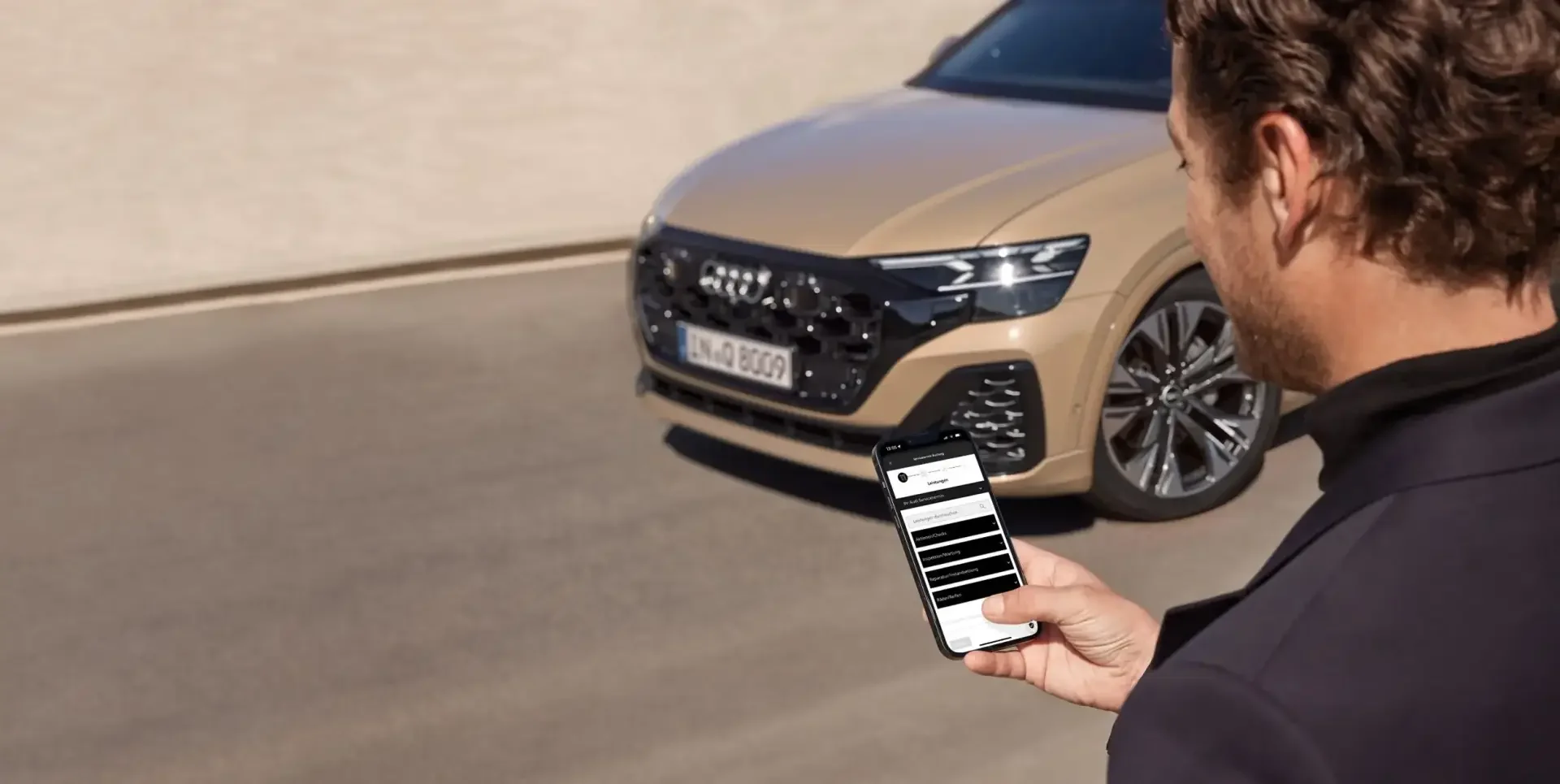 Mann bedient MyAudi, brauer Audi im Hintergrund
