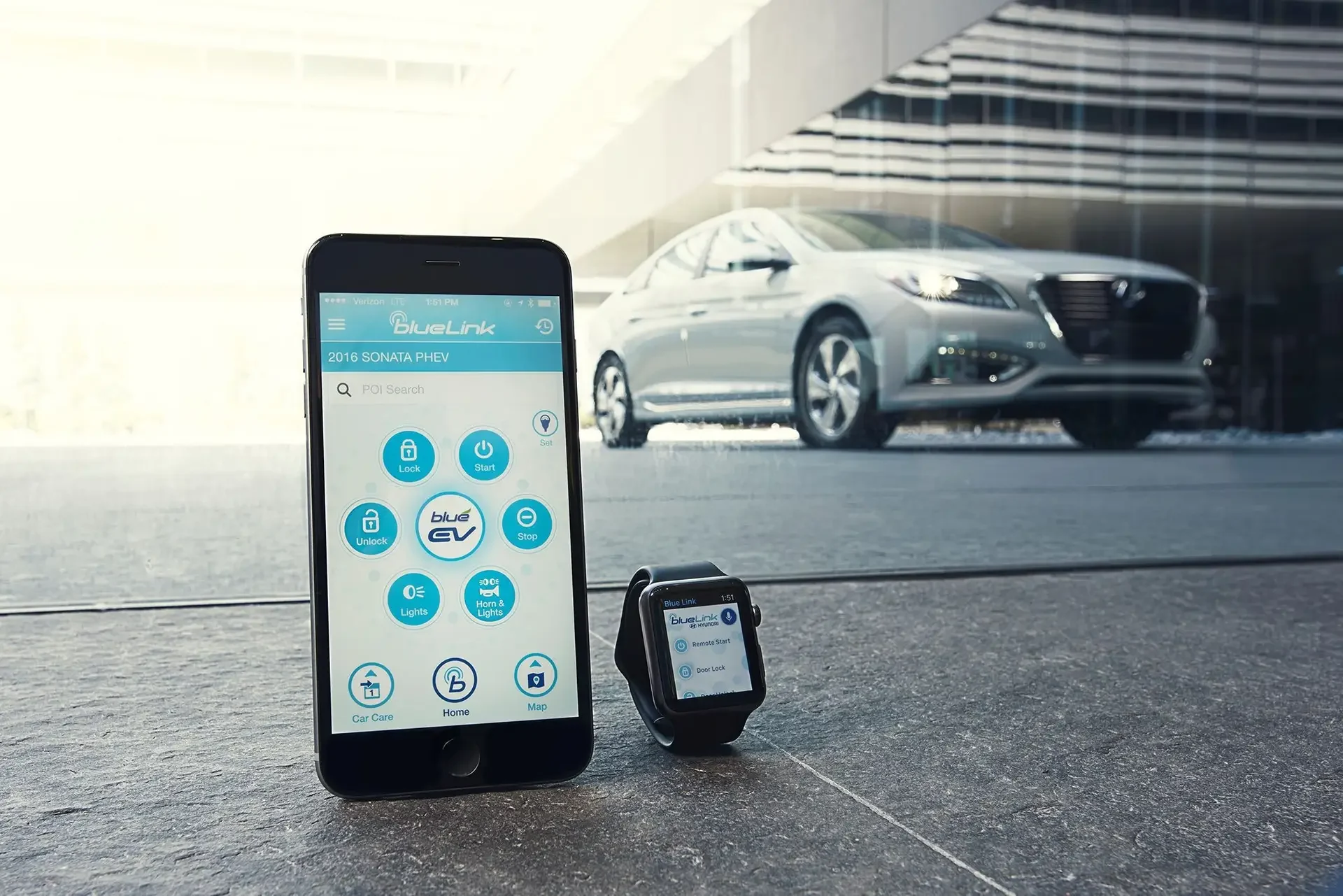 Geöffnete BlueLink App auf einem Smartphone und Smartwatch mit einem Hyundai im Hintergrund