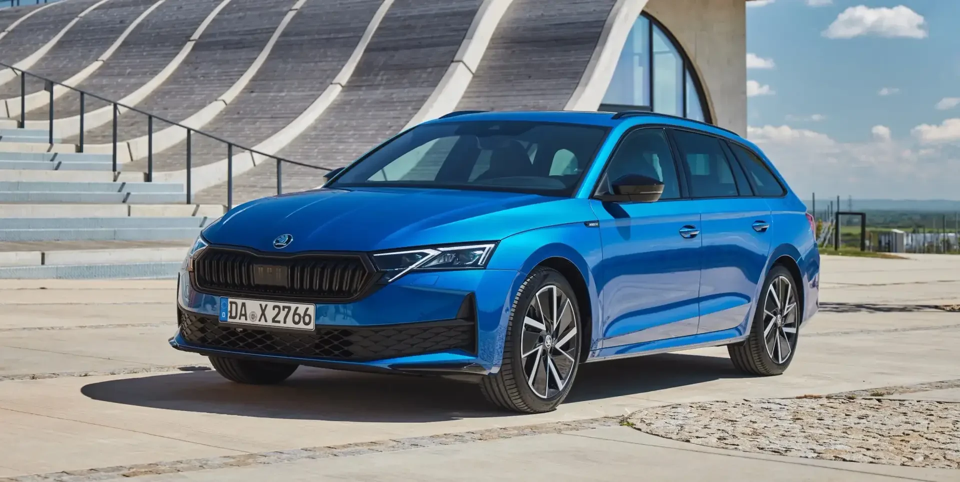 Blauer Skoda auf dem Parkplatz vor Gebäude