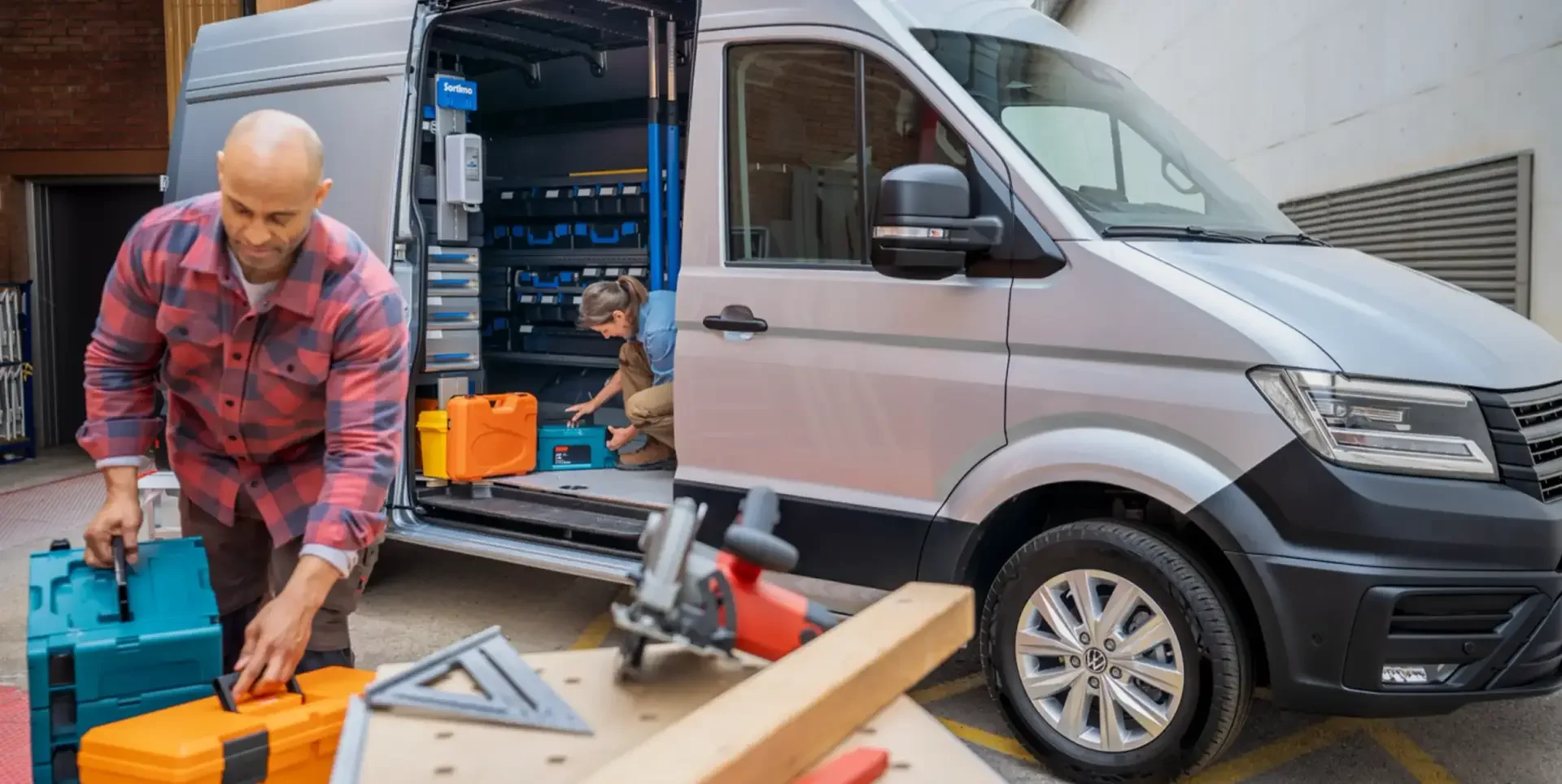 VW Nutzfahrzeug offen als Werkstattbulli, Mann und Frau am Handwerkern